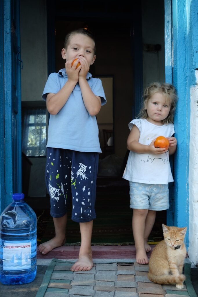 Kids enjoying a little present from the neighbours: homegrown tomatoes. © Kseniia Tomchyk